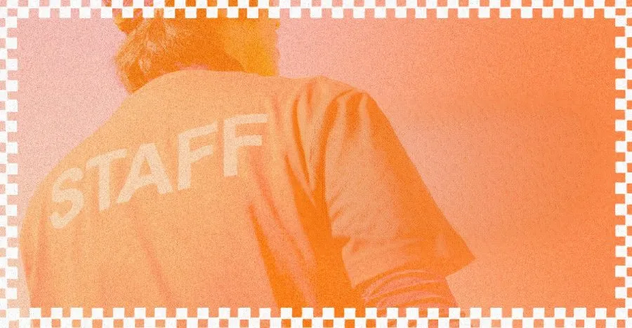 Homem de costas com camiseta de "staff", representando os volunt&aacute;rios na igreja