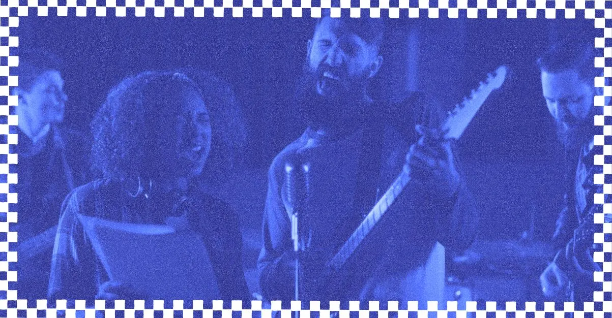 Mulher tocando violão e sorrindo durante ensaio musical, representando dicas para ministério do louvor com foco em prática e dedicação.