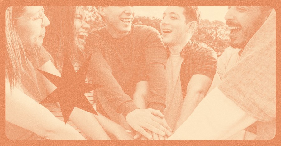 Grupo de jovens sorrindo e unindo as mãos ao centro em gesto de parceria, com filtro laranja, em atividade do ministério de jovens